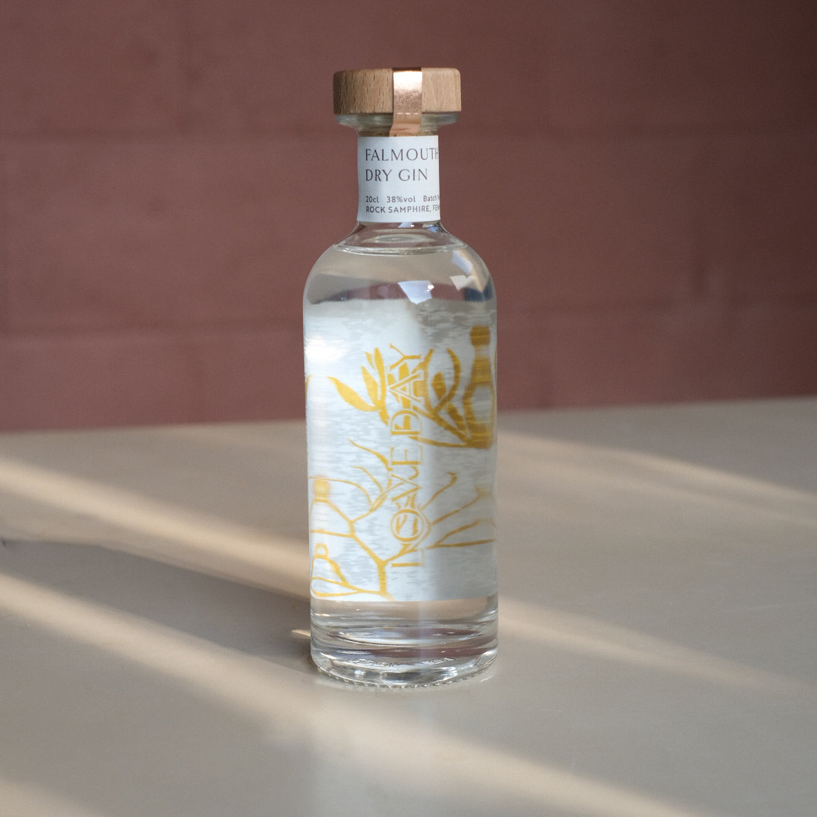 Falmouth Dry Gin 20cl bottle by Loveday Distillery with golden botanical label and wooden cap, shot in warm natural light