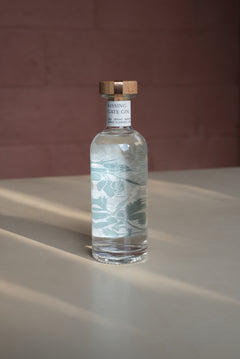 Kissing Gate Gin 30cl bottle with wooden cap and sage botanical label design, warm studio lighting
