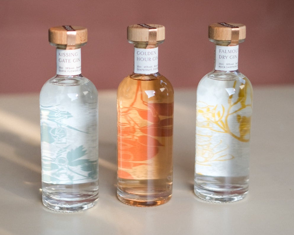 Three Loveday Distillery gin miniatures: Kissing Gate, Golden Hour, and Falmouth Dry, with copper caps on a neutral surface