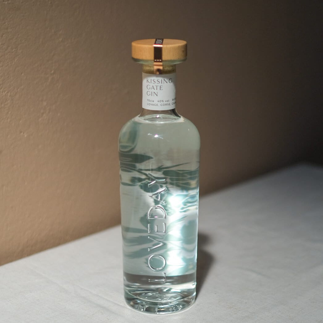 Loveday Distillery Kissing Gate Gin in a clear glass bottle with gold cap on a white surface