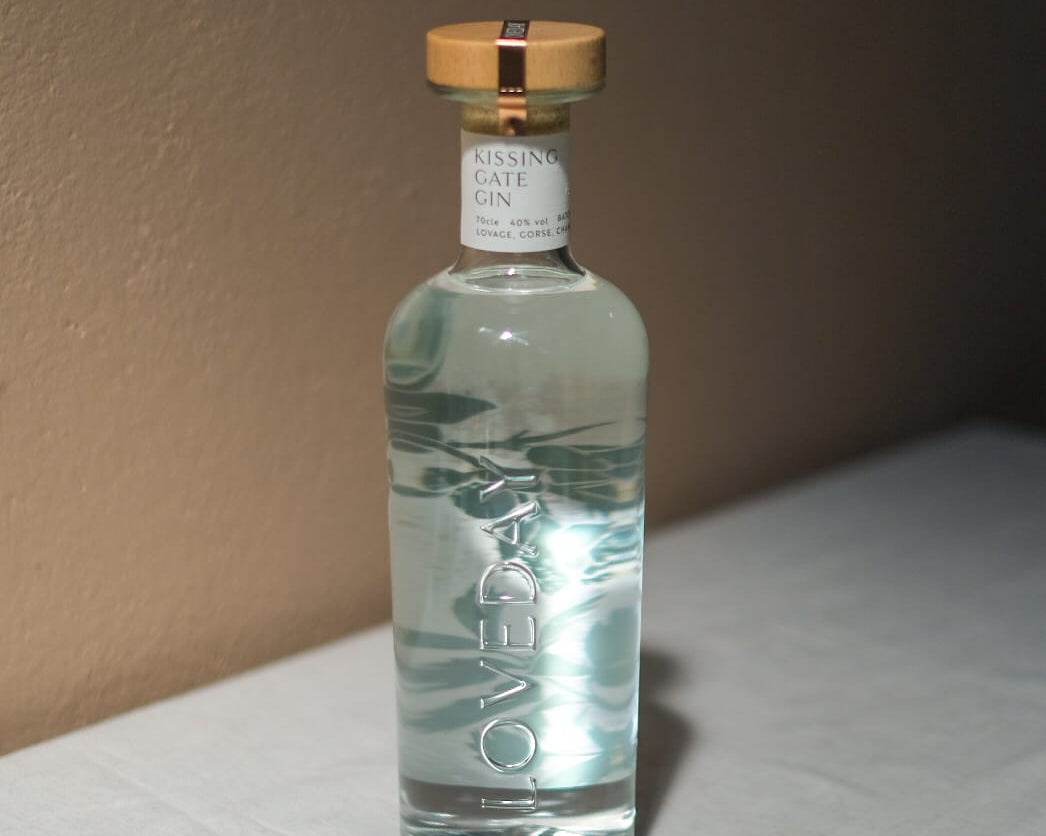 Loveday Distillery Kissing Gate Gin in a clear glass bottle with gold cap on a white surface